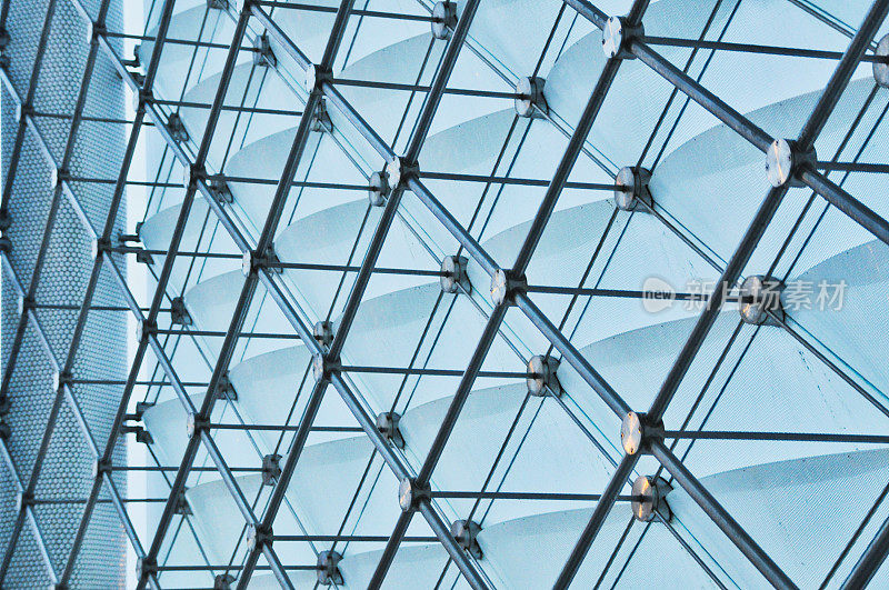 由玻璃板和金属梁组成的复杂几何结构，突出了复杂的建筑设计和光影的相互作用