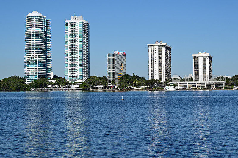 位于佛罗里达州迈阿密的住宅海滨塔楼映照在比斯坎湾上。