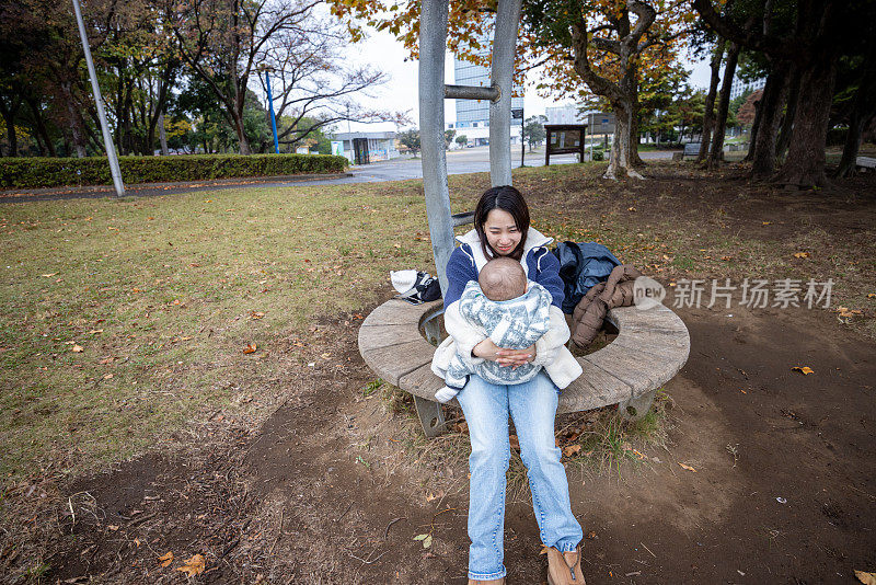 在公园里抱着孩子的女人