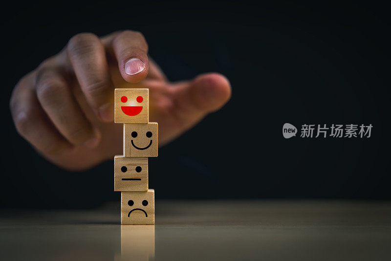 手堆叠情感表达块。一只手正在堆砌各种表情的木块，象征着对情绪的管理。象征顾客满意的理念。