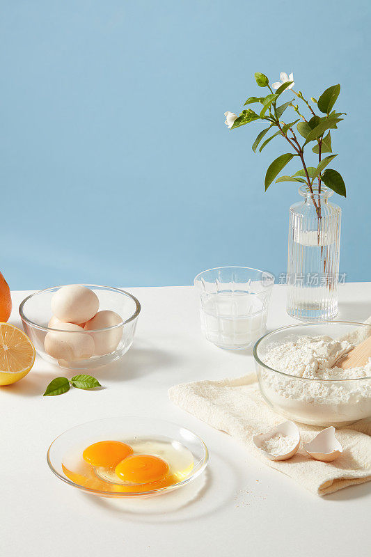 准备早餐或早午餐，用面粉，鸡蛋，牛奶和柠檬装饰美丽的花瓶。展示烹饪产品的空白空间