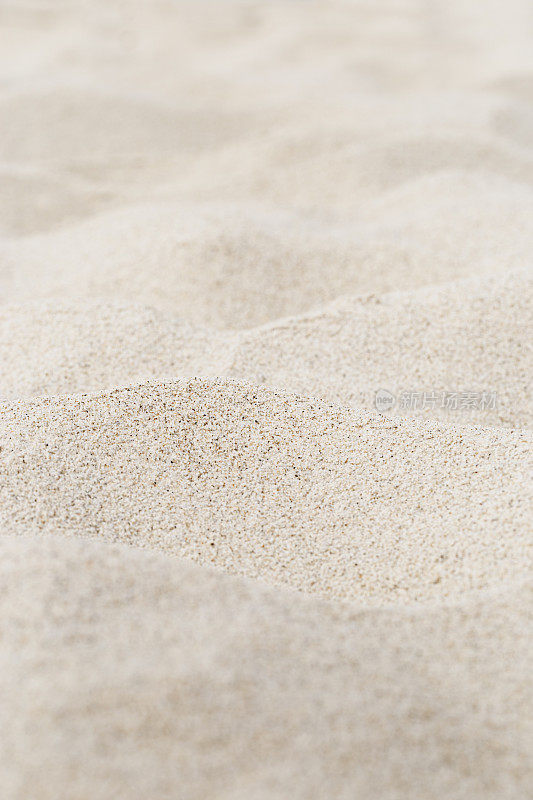 米色砂纹理自然背景。沙丘上的近距离波浪图案，最小的自然垂直背景，查看海滩。夏季和旅游，水疗和放松的概念。有选择性的重点。