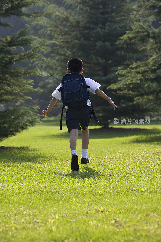 在草地上奔跑的小学生