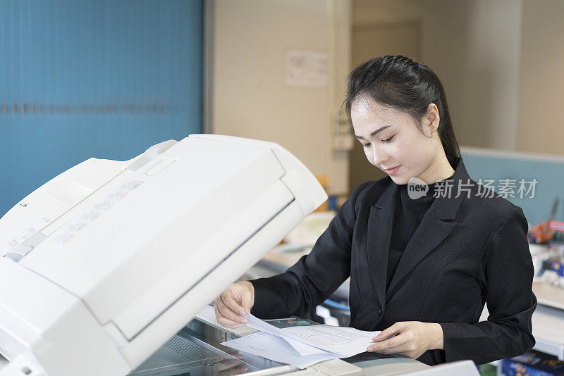 亚洲女秘书在办公室使用复印机