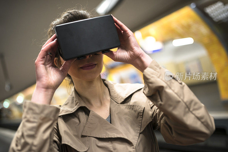 一名女子在地铁站内使用虚拟现实模拟器