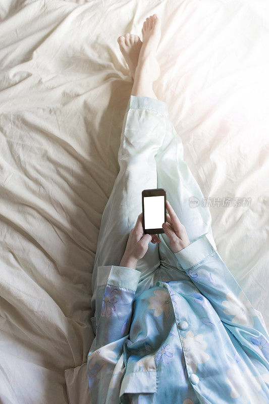 女人在床上玩智能手机