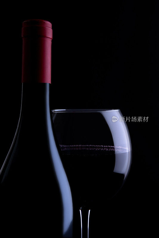 孤立的酒瓶和酒杯的红酒在黑色的背景