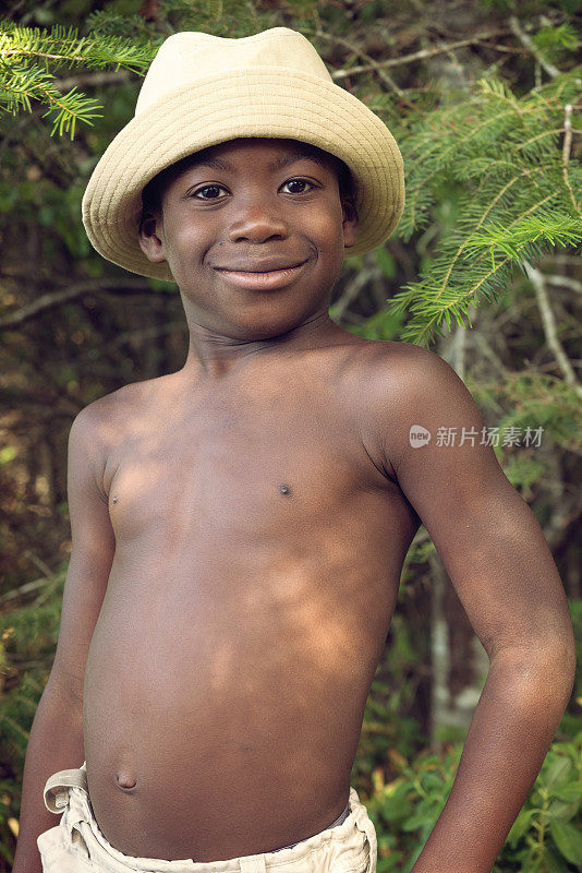 戴着帽子的非洲裔美国小男孩在大自然中摆姿势。
