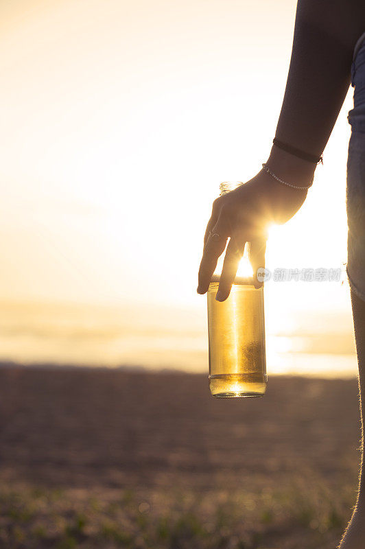 在海滩上喝啤酒的女人