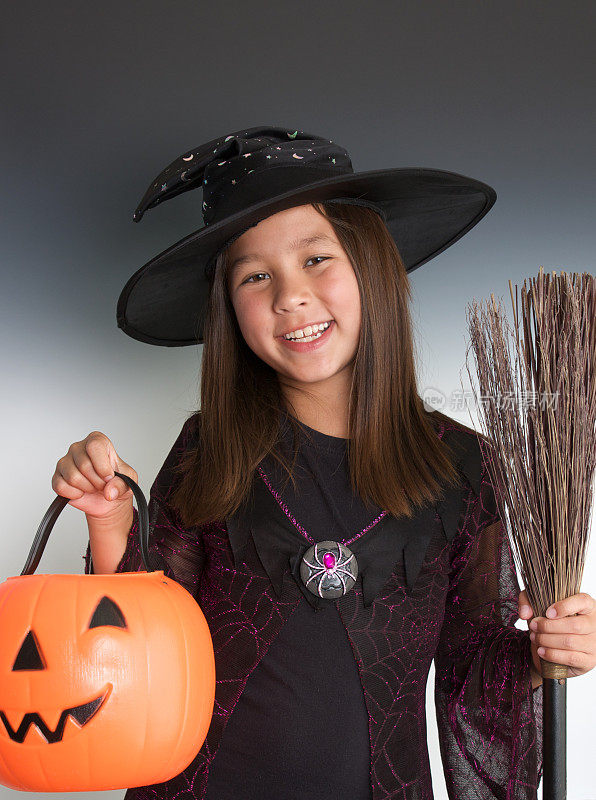 可爱的九岁的巫婆恶作剧或糖果的万圣节