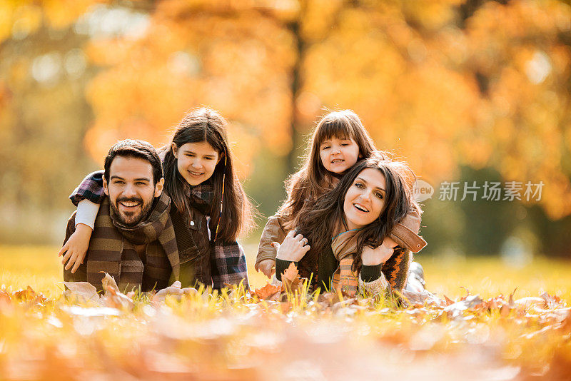 秋日，一家人微笑着在草地上休息。