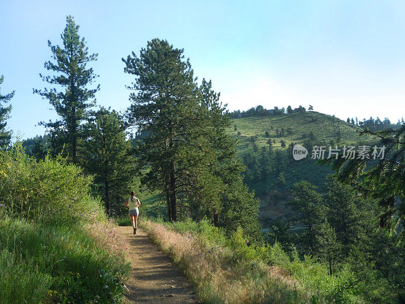 一名年轻女子在科罗拉多的落基山脉的熊溪上奔跑