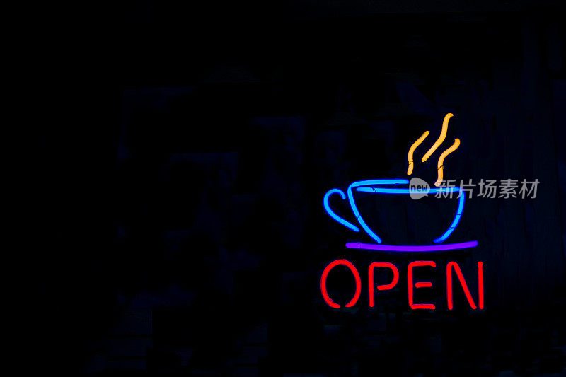 黑色窗户上的“打开”霓虹招牌和咖啡杯