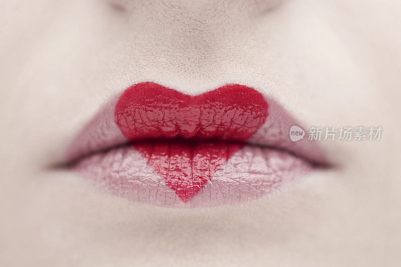 心脏形状的特写与红色的口红在嘴唇上