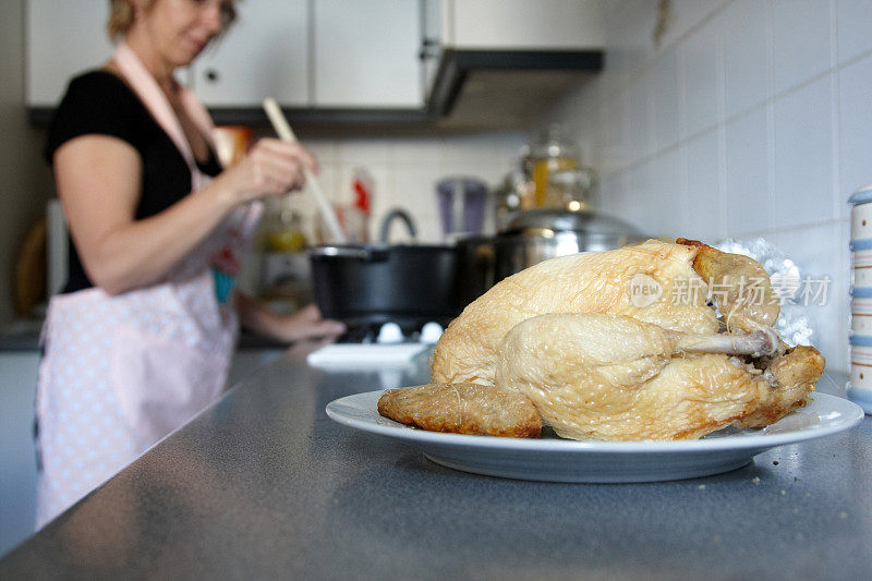 家庭主妇在厨房准备食物烤鸡的前景
