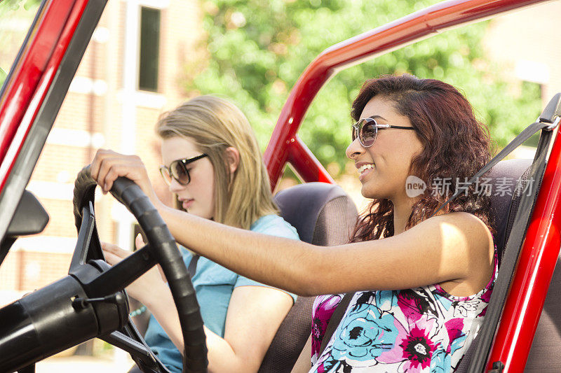 多民族少女进行夏季公路旅行。驾驶车辆。