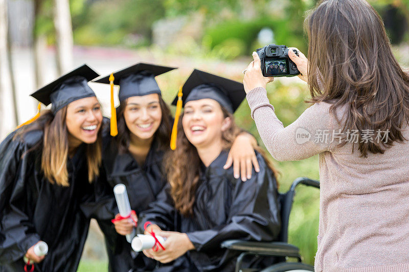 兴奋的大学女生摆姿势拍照毕业后