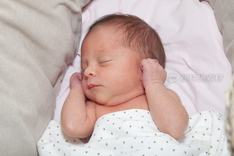 刚出生六天的女婴抱着胳膊睡觉