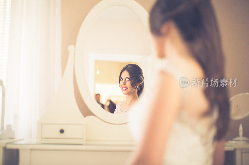 年轻美丽的新娘照镜子