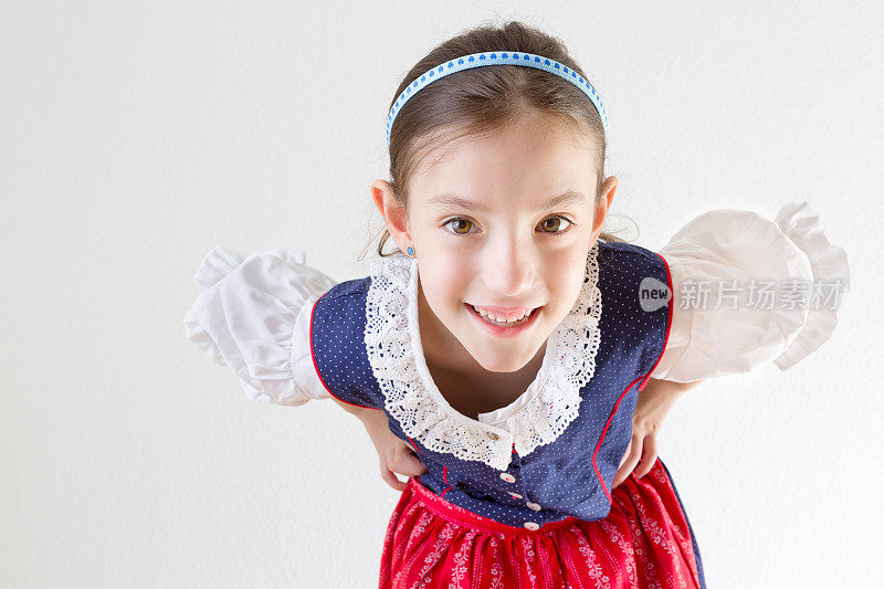 巴伐利亚小女孩穿着传统连衣裙，看着镜头