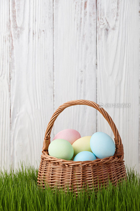 草地上放着复活节彩蛋的篮子