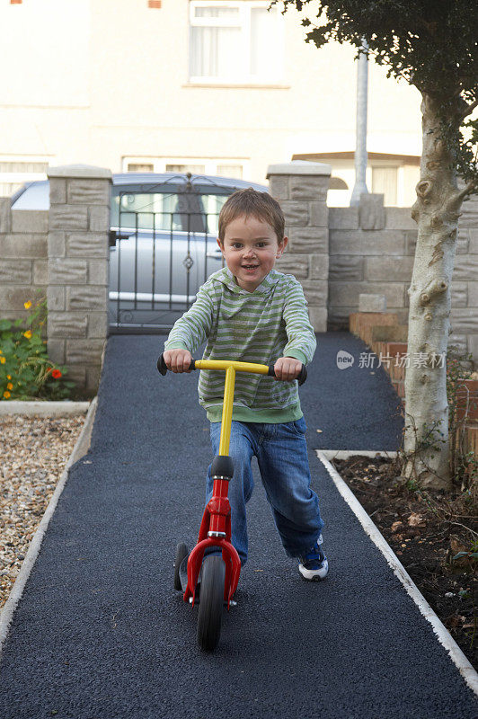小男孩骑着他的滑板车