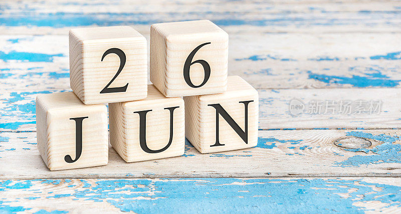 6月26日。木制立方体与日期6月26日在旧的蓝色木制背景。