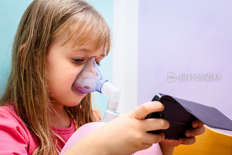 小女孩在使用吸入器之前一直在手机上玩游戏