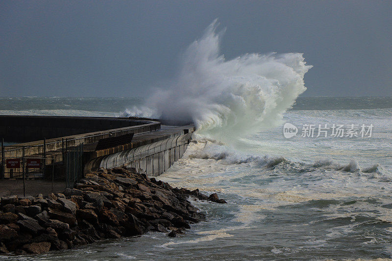 在大西洋海岸线上，巨大的风暴潮到达一个码头上的防波堤。Cascais葡萄牙