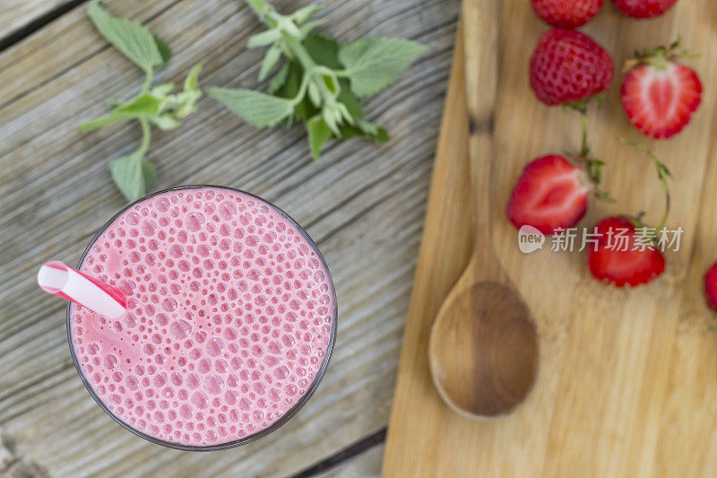 草莓奶昔。木桌上的健康早餐超级食物