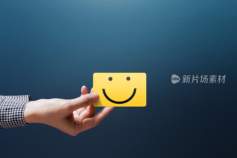 顾客体验概念，快乐的顾客女展示一个反馈与快乐的笑脸卡