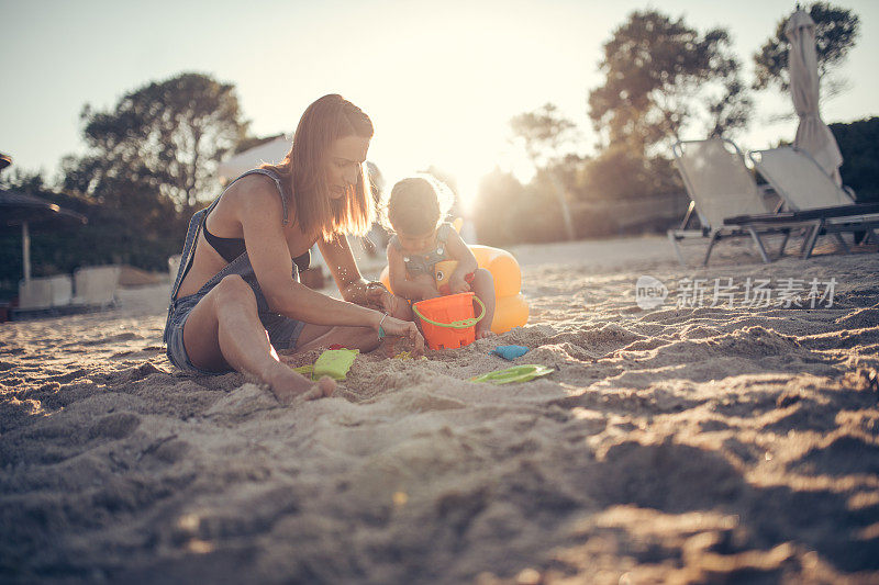 妈妈和女儿在玩沙子