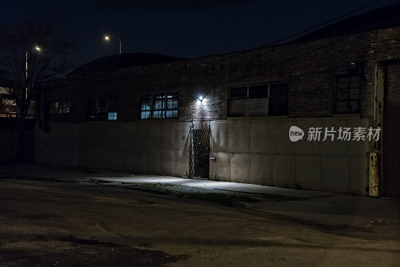黑暗可怕的巷子在晚上与大门仓库入口。