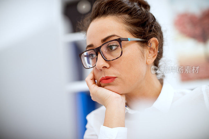近距离观察专注的职业女性在办公室的笔记本电脑上工作。