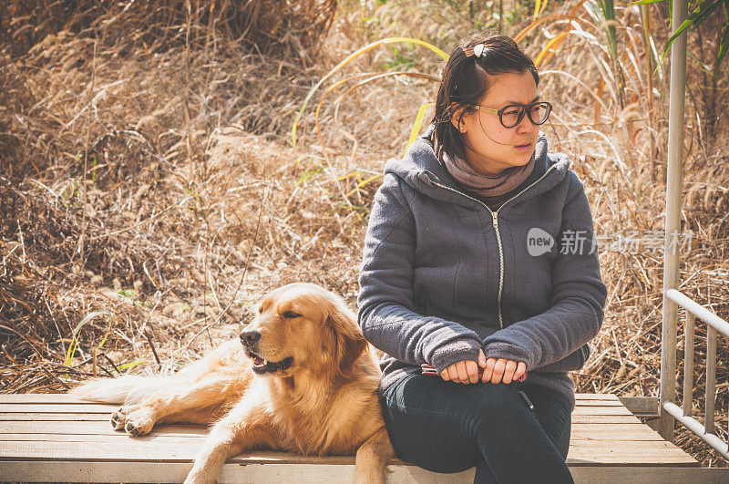 一个亚洲女人和一只金毛猎犬