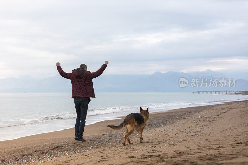 海滩上的年轻人和他的狗