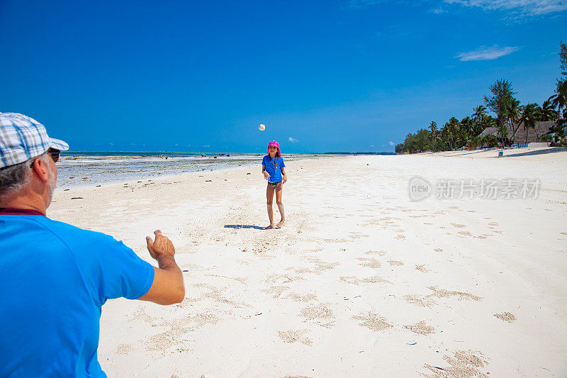 父亲和女儿在白色沙滩上玩耍