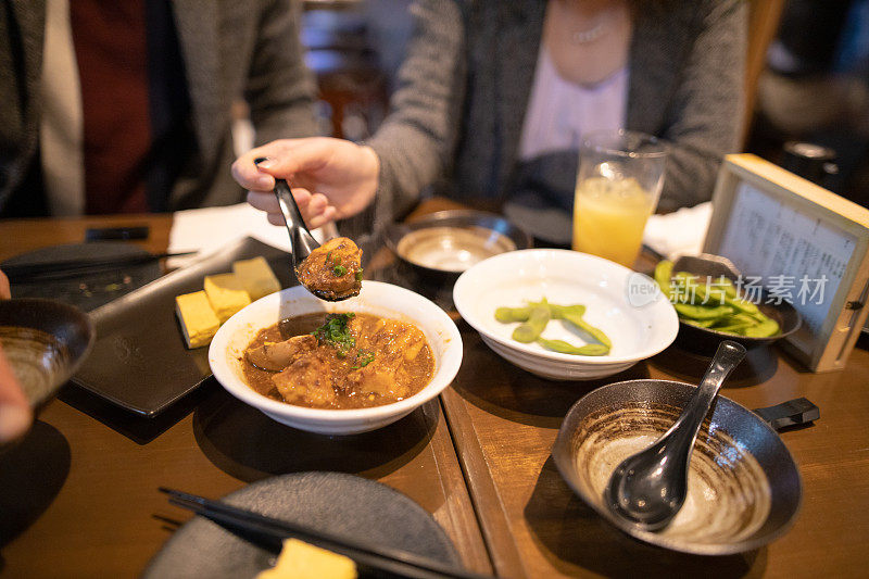 在居酒屋户外餐厅吃日本食物的商人