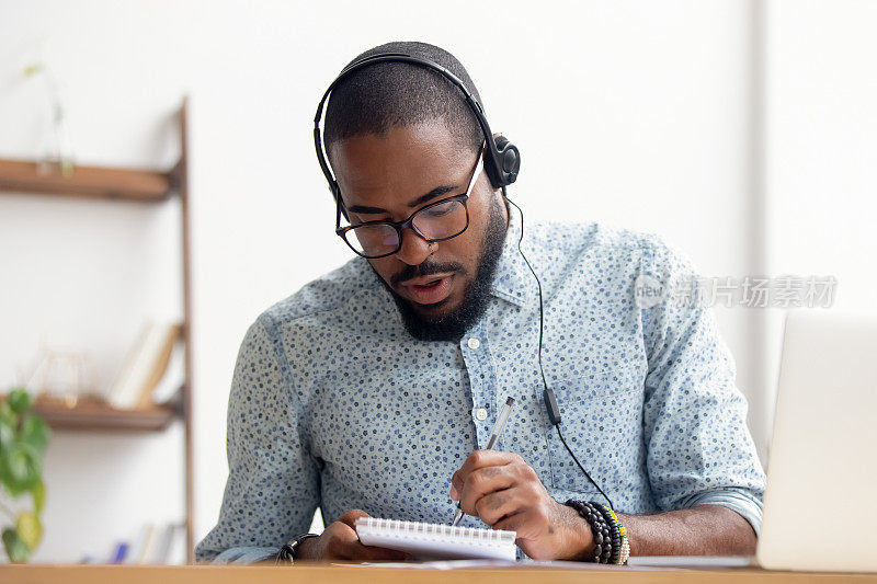 非裔美国人戴着耳机在办公室学习电子学习课程