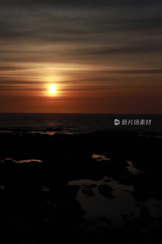 日出越过岩石和大海