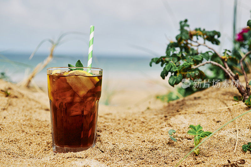 夏日的海滩上，一杯薄荷柠檬冰茶。