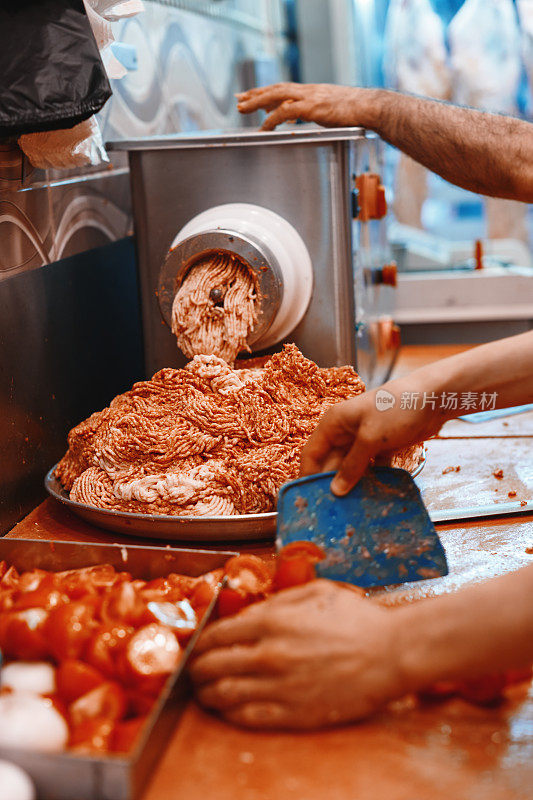 肉馅研磨机。厨师正在为美味的烤肉串准备原料