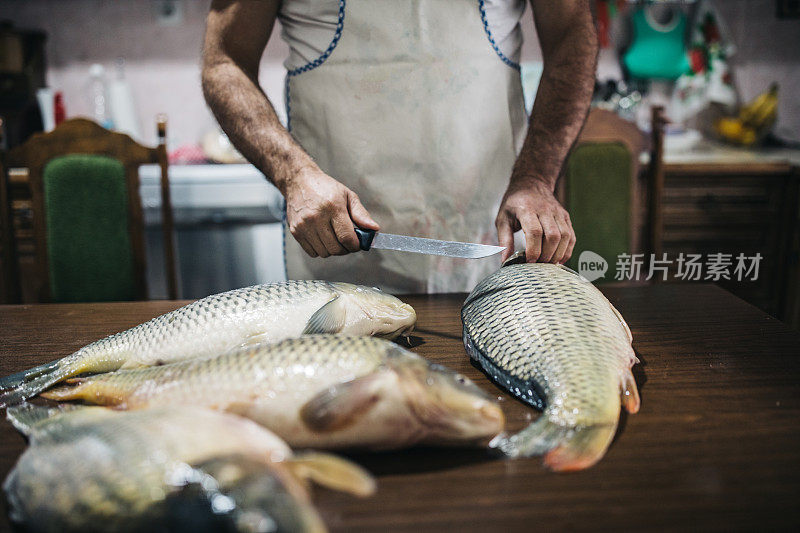 男子在家里的厨房里准备鲤鱼河鱼烹饪健康饮食食品
