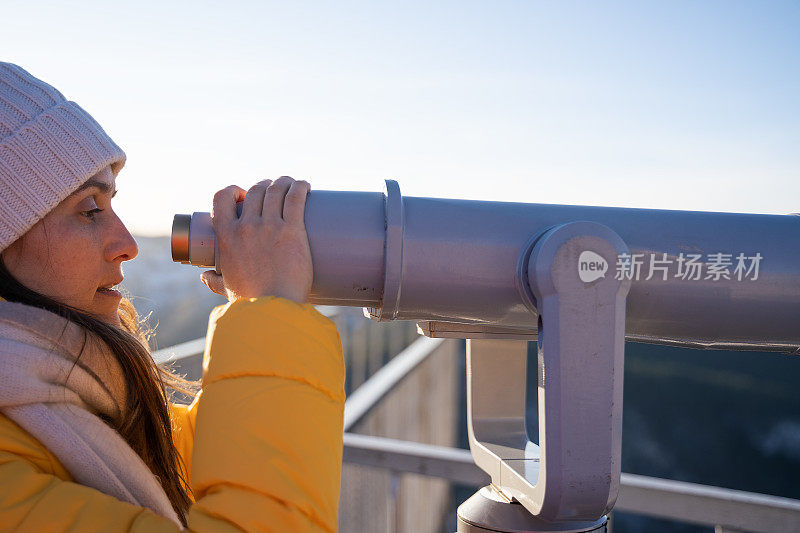 观点。独自旅行者在一个美丽的全景从高山上。冬天阳光明媚的户外享受。旅游目的地。用观光望远镜看。全景望远镜。