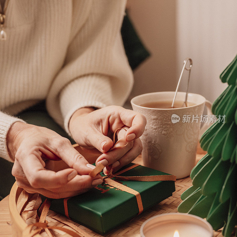 女人一边包装礼物一边喝茶