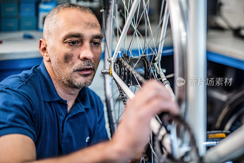 修理工在修理自行车变速器时弄脏了。