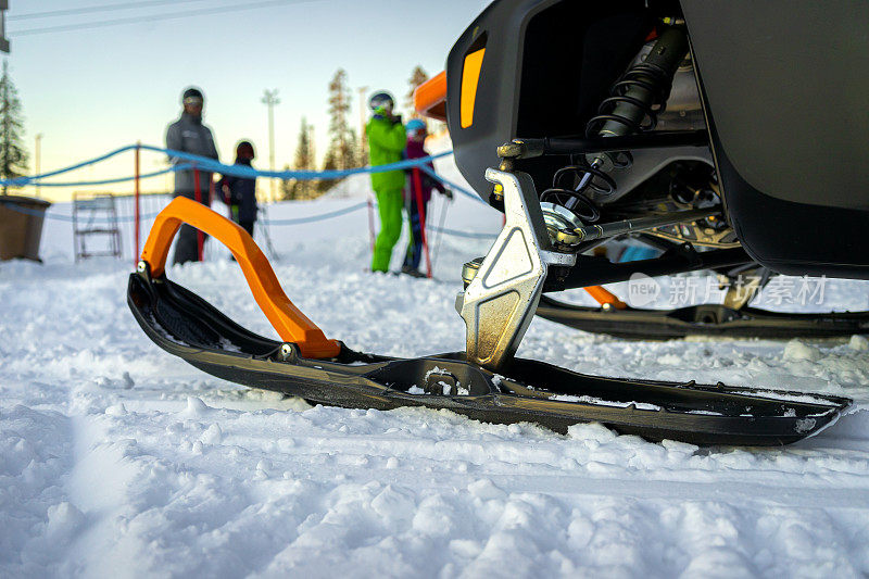 在滑雪胜地的雪地摩托的滑雪运动员的特写镜头