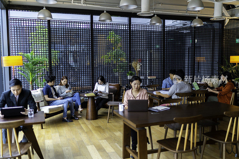 亚洲千禧一代在繁忙的共同办公区工作