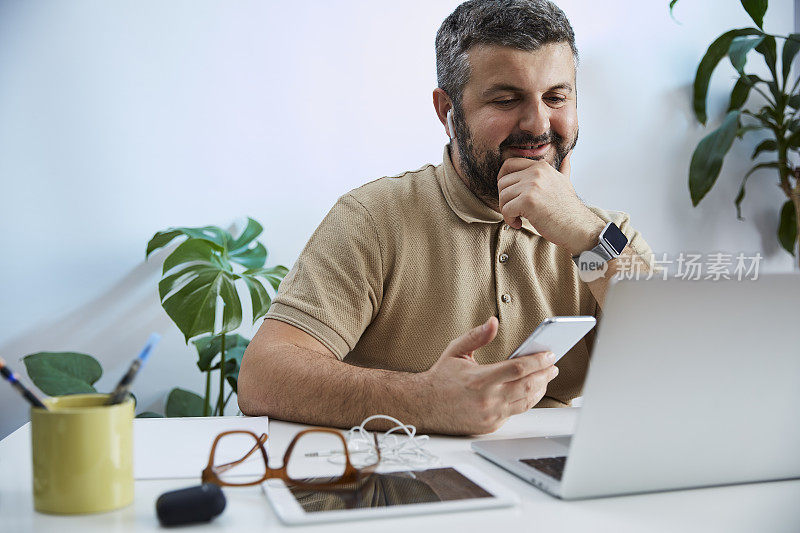 一个年轻人在他的家庭办公室里对着电脑说话