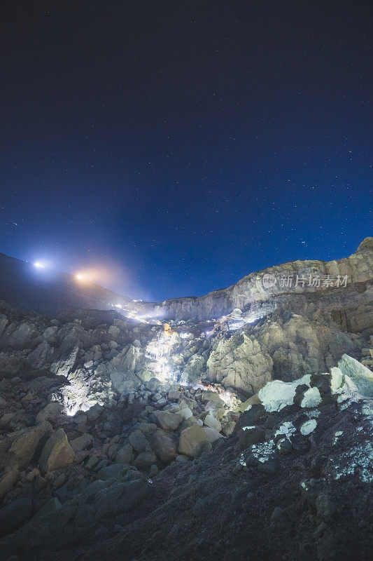 硫磺湖和冒烟的矿山山早上在卡瓦伊真火山印度尼西亚东爪哇与银河夜空的背景